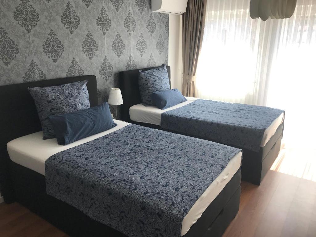 1 Schlafzimmer mit 2 Betten mit blauer und weißer Bettwäsche in der Unterkunft Maxim Apartments Mainz in Mainz