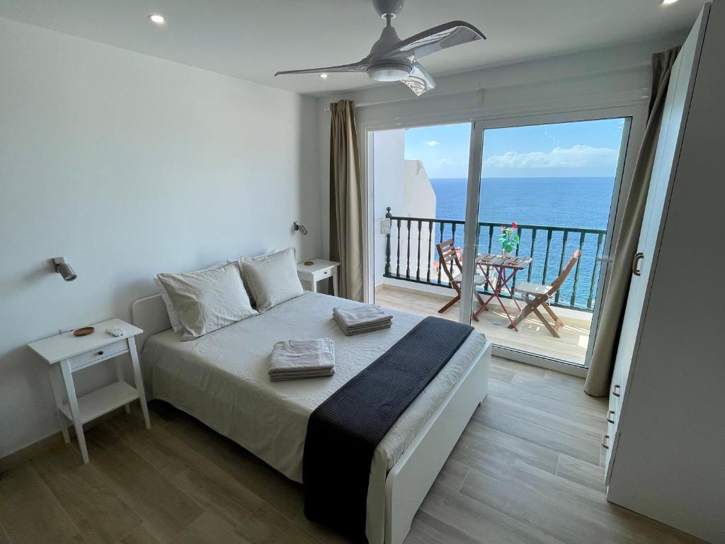 1 dormitorio con 1 cama y balcón con vistas al océano en Amazing sea views from cozy studio., en Puerto de Santiago