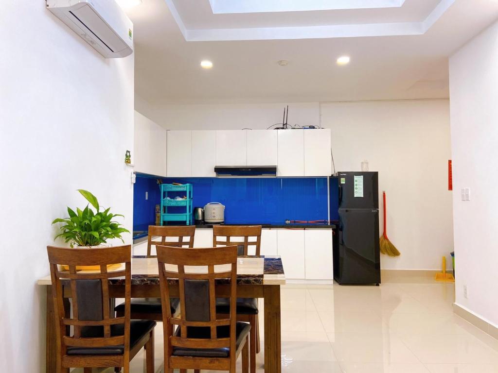 a kitchen with a table and chairs and a refrigerator at Căn Hộ Nghỉ Dưỡng Melody Vũng Tàu - Tomorrow HomeStay 3 in Vung Tau