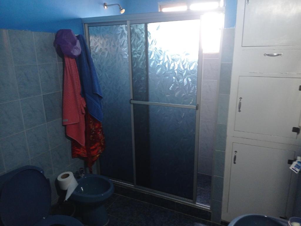 a shower with a glass door in a bathroom at Casa Ituzaingó in Minas