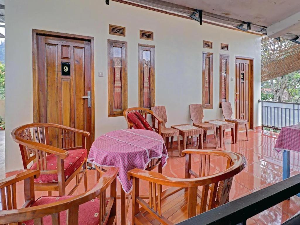 uma fila de mesas e cadeiras num quarto em Adinda Homestay Lembang em Lembang