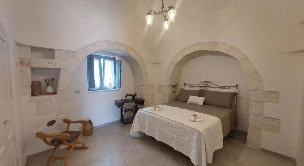 1 dormitorio con 1 cama en una habitación con arcos en Trullo La chicca della valle, en Cisternino
