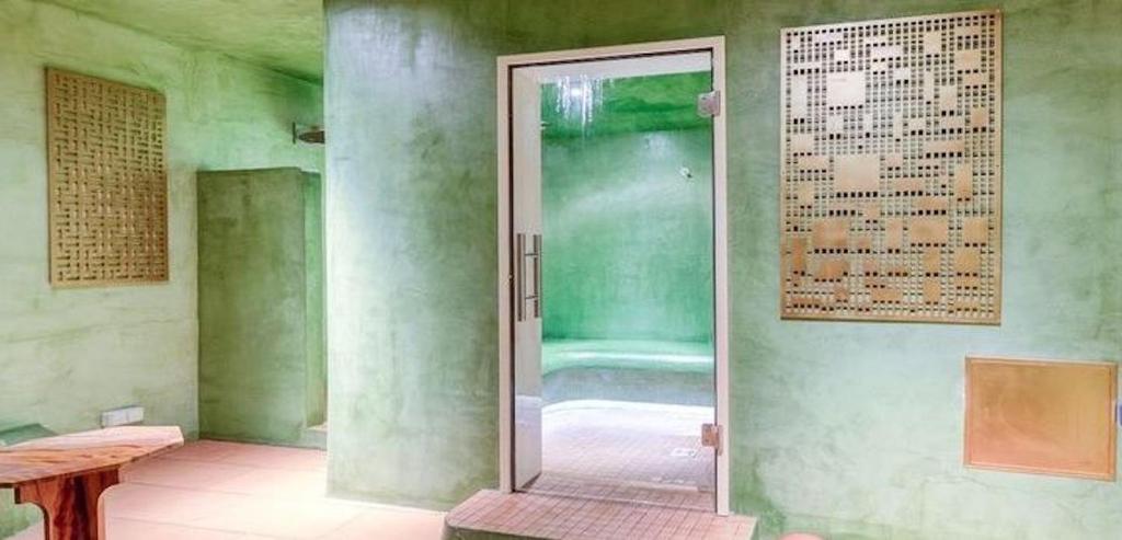 a glass door in a room with a shower at Hôtel La Nouvelle République & Hammam in Paris