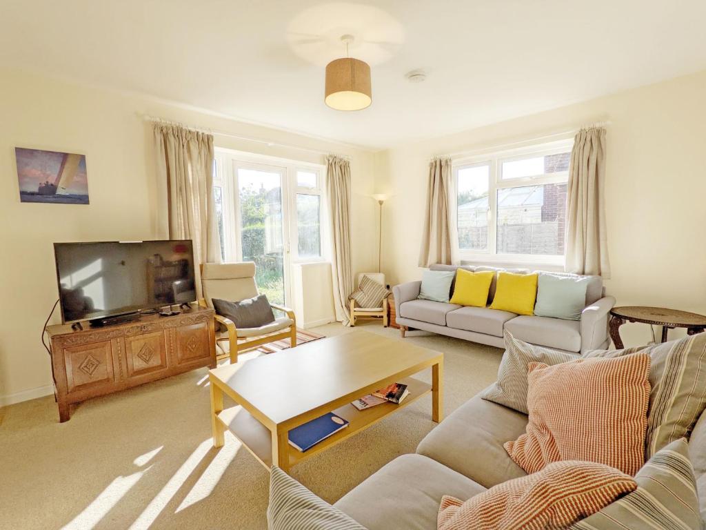 a living room with a couch and a tv at Beacon Square, Emsworth in Emsworth