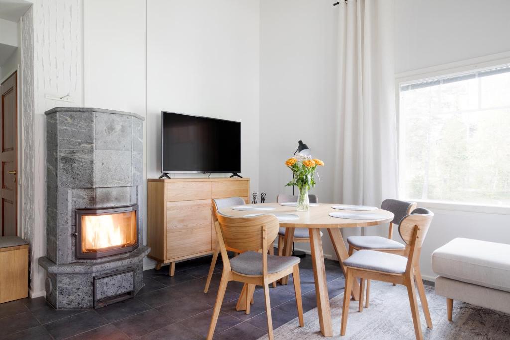a living room with a table and a fireplace at Alppitähti, Huoneisto Hilla in Levi