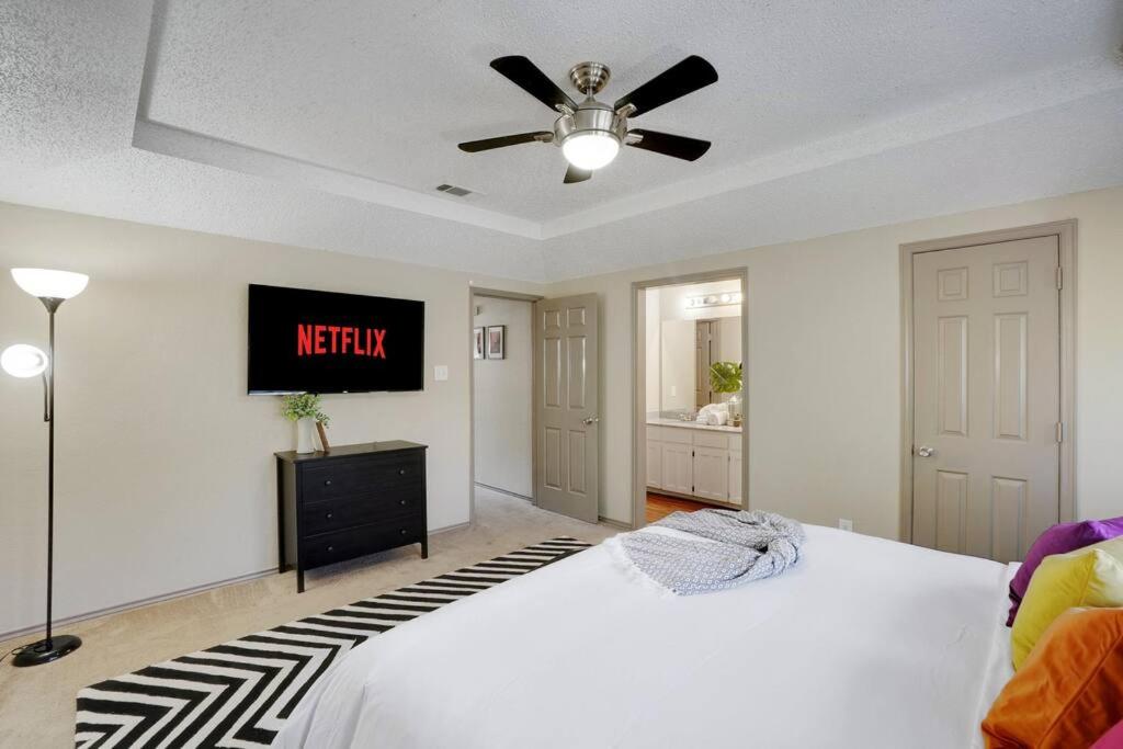 um quarto com uma cama e uma televisão na parede em ¤The Wild Clover¤ •Pets ok•Arcade•Garage• 《NFLX》 em Euless