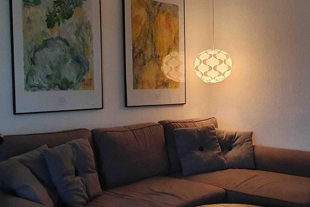 um sofá numa sala de estar com fotografias na parede em Nice and cozy flat em Nuuk