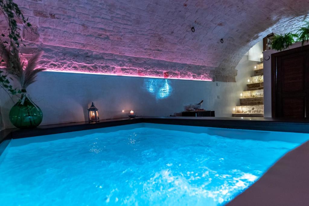 una gran piscina en una habitación con una pared de ladrillo en B&B Panaro, en Alberobello