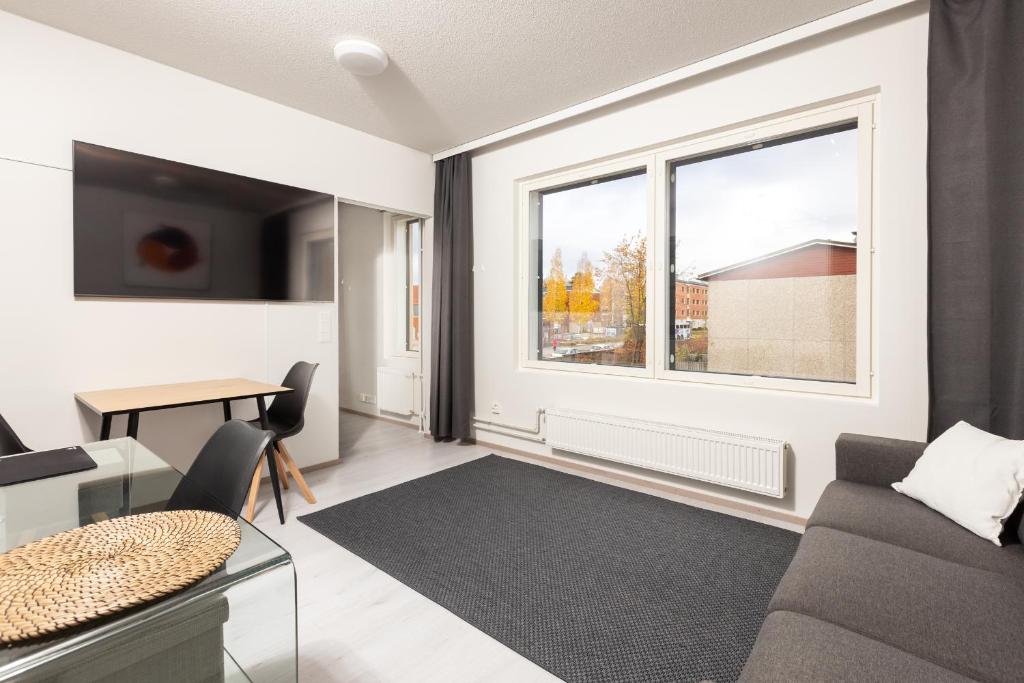 uma sala de estar com um sofá e uma janela em Valoisa parvekkeellinen kaksio, oma parkkipaikka em Tampere