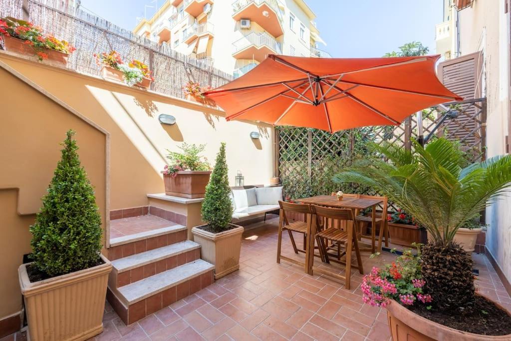 patio ze stołem, parasolem i schodami w obiekcie [CASA GIANNI 5 STELLE] Apartment with garden w Rzymie