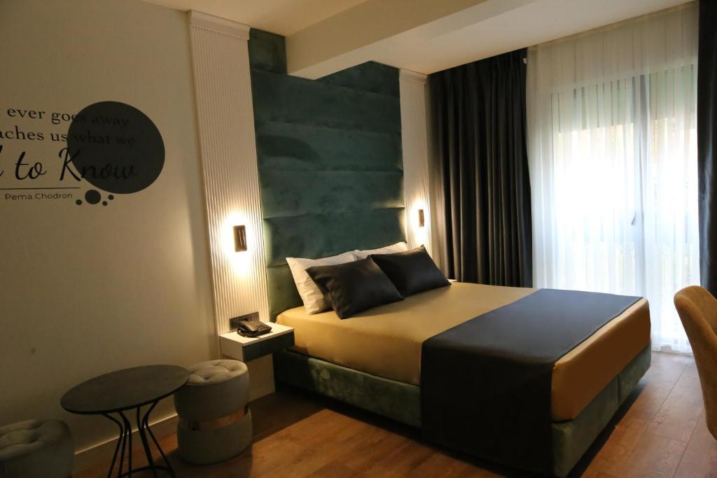 a bedroom with a bed and a table in a room at AXU AIRPORT HOTEL in Arnavutköy