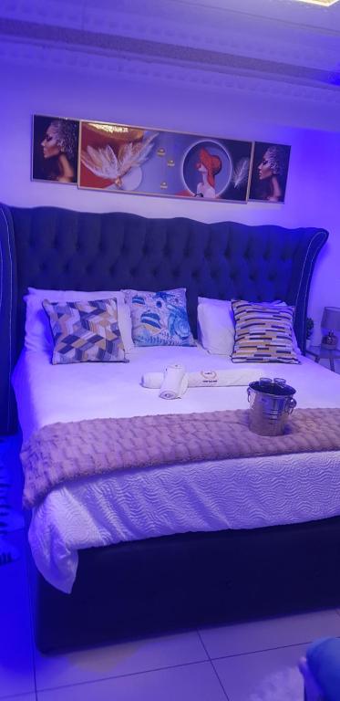 un letto in una camera con immagini appese al muro di Ko-Porch luxury guest house a Polokwane
