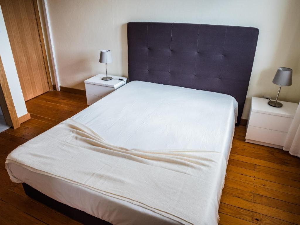 a bedroom with a large white bed with two night stands at Casa Ferradal 