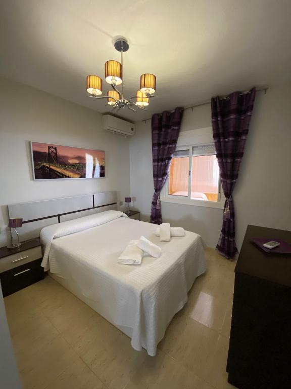 ロケタス・デ・マルにあるApartamento Aguadulce Playaのベッドルーム1室(大型ベッド1台、タオル2枚付)