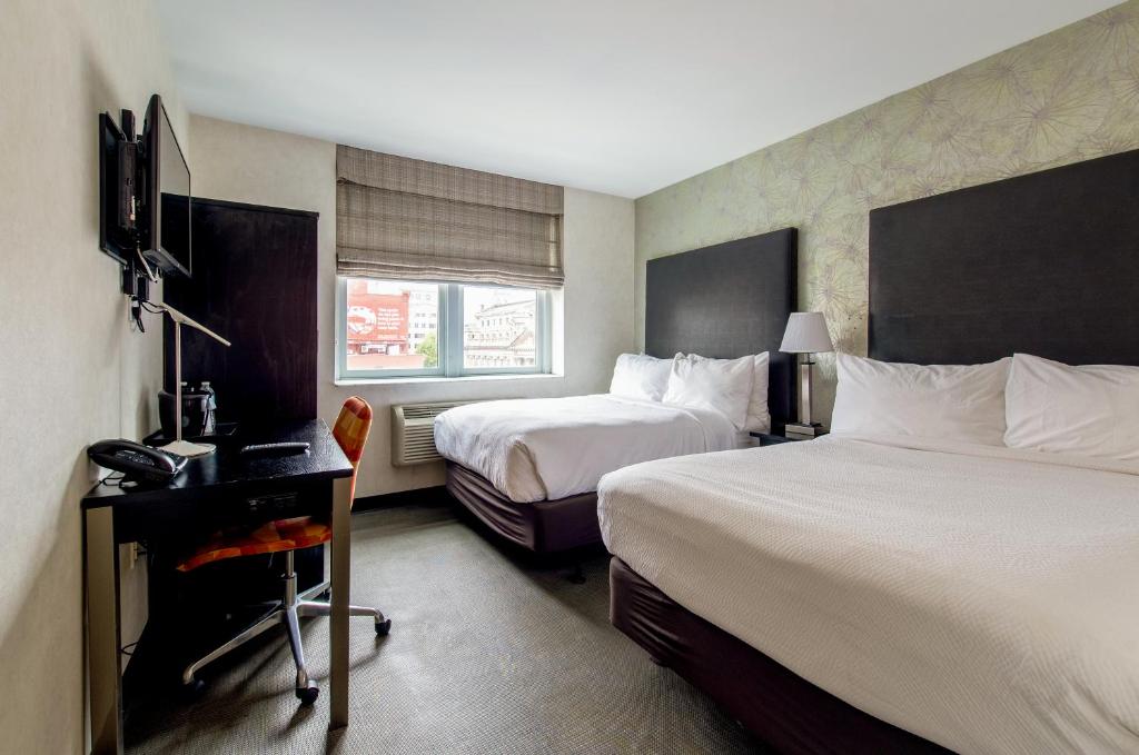 ein Hotelzimmer mit 2 Betten und einem Schreibtisch in der Unterkunft Solita Soho Hotel in New York