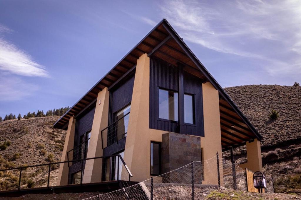 una casa en una colina con una valla alrededor en El Mirador en Esquel