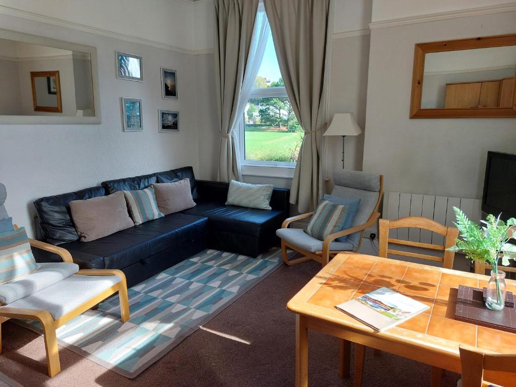 uma sala de estar com um sofá e uma mesa em Abbey View Holiday Flats em Torquay