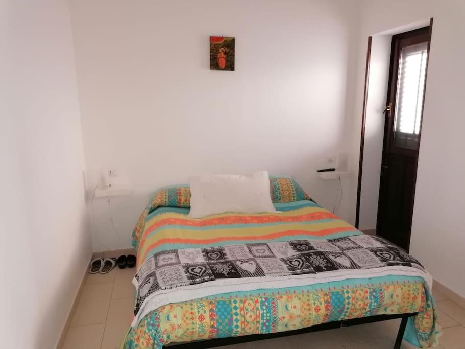 een slaapkamer met een bed met een quilt bij Casa Sofia Favignana in Favignana