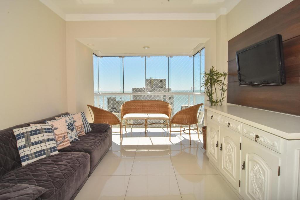 uma sala de estar com um sofá e uma televisão de ecrã plano em Vista Mar na quadra do Atlântico Shopping P1287 em Balneário Camboriú
