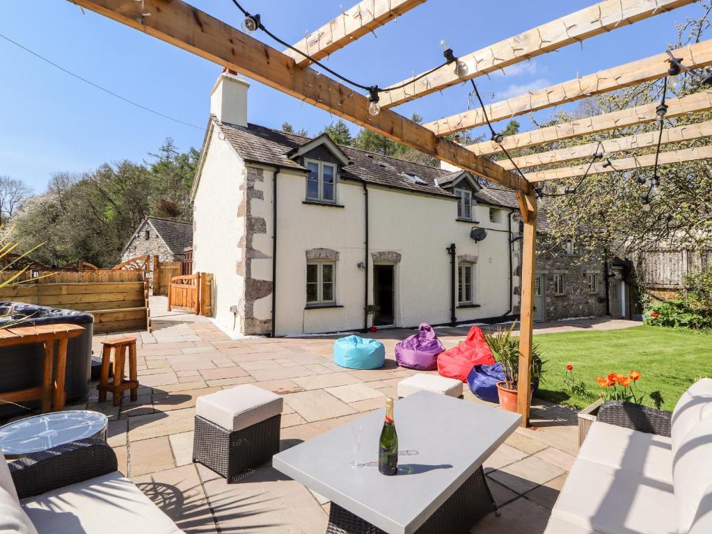 a patio with a white table in front of a house at Nant Y Celyn in Ruthin