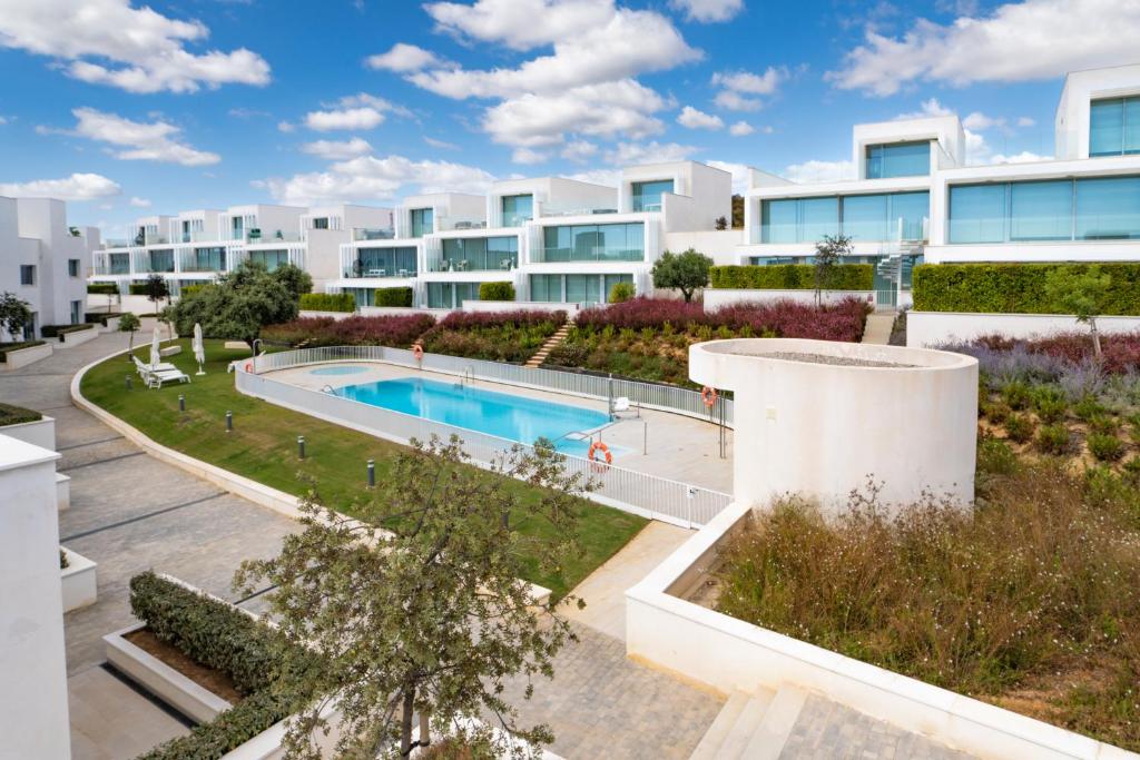 ein Bild eines Apartmentkomplexes mit einem Pool in der Unterkunft Villa La Perla Sotogrande - since 2022 - Sea View - 3 Bedrooms and Bathrooms - La Reserva Beach and Golf nearby in Sotogrande