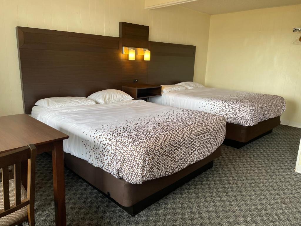 um quarto de hotel com duas camas e uma mesa em Holiday Motel em Westport