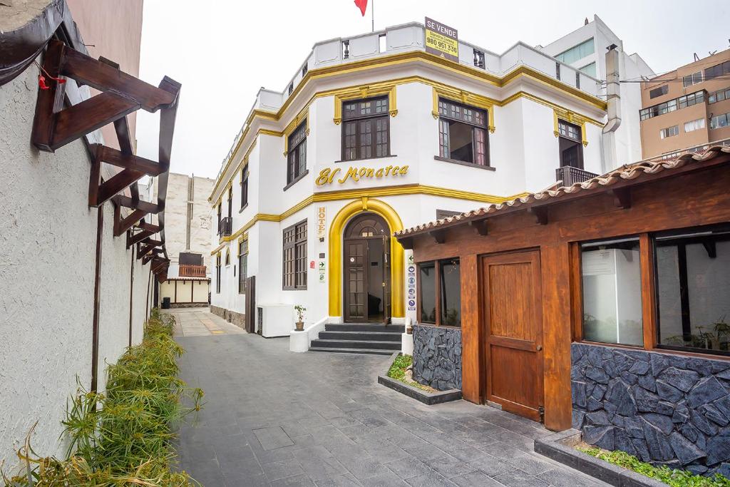 un edificio blanco y amarillo en una calle en El Monarca Miraflores, en Lima