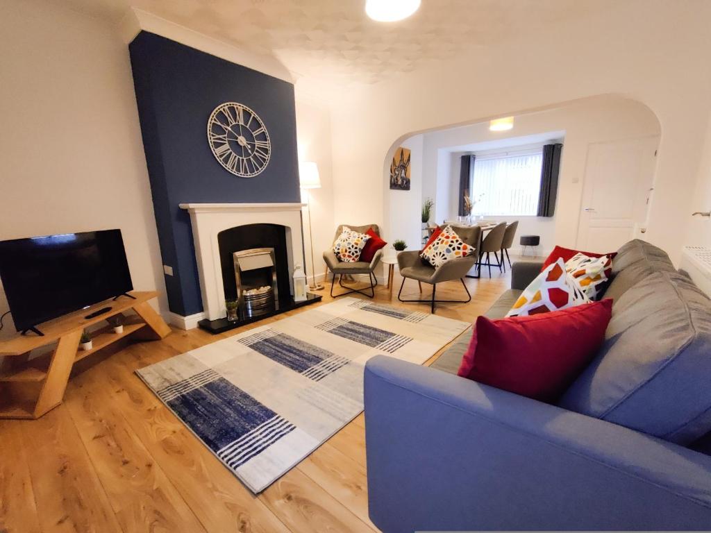 uma sala de estar com um sofá e um relógio na parede em St Johns Hse, 3 BR, Sleeps 6, FREE Parking, Contractor, WiFi, Kitchen, Garden em Doncaster