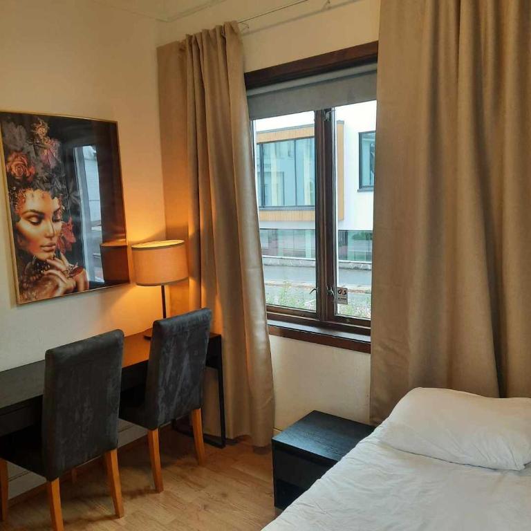 a bedroom with a desk and a bed and a window at Guesthouse- Møllegata 39 in Stavanger