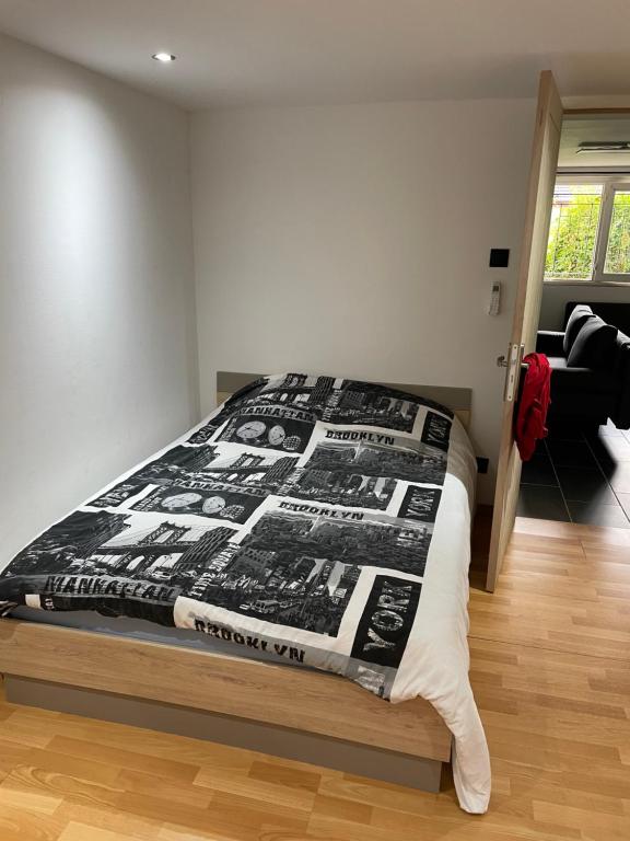 - une chambre avec un lit doté d'une couette noire et blanche dans l'établissement Charmant logement avec cheminée,cour,wifi,Netflix, à Blanzy