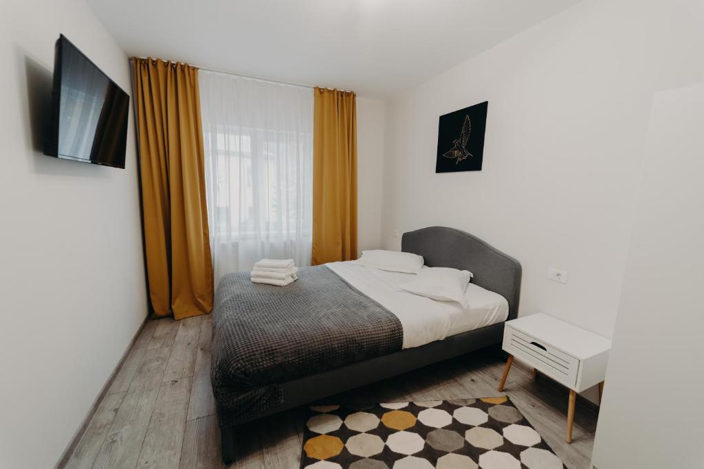 a bedroom with a bed and a tv and a window at Apartamentul Galben in Vatra Dornei