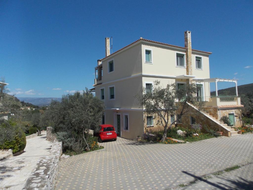czerwony samochód zaparkowany przed białym domem w obiekcie family house in Nafplio w Nauplionie