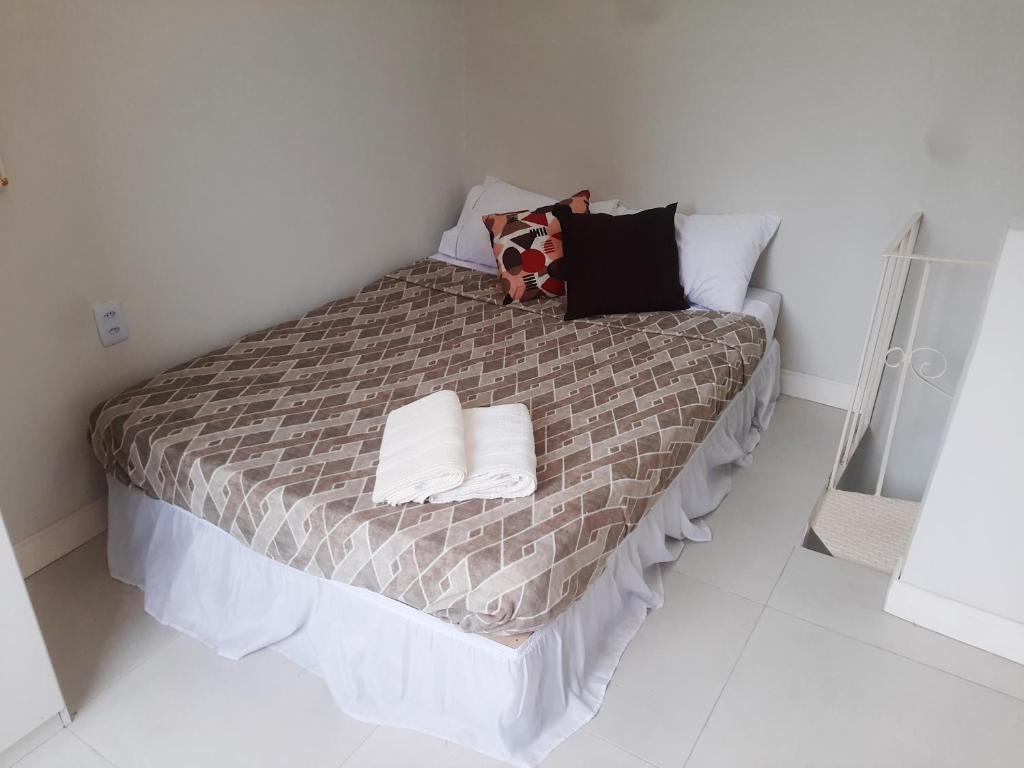 a bedroom with a bed with two pillows on it at Leblon Central in Rio de Janeiro