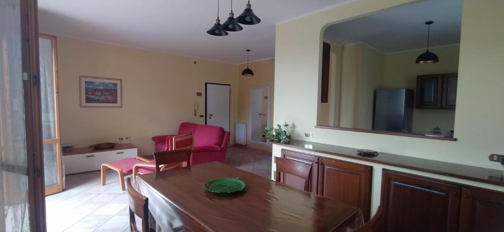 un soggiorno con tavolo, sedie e specchio di Appartamento a Castellarano Manzoni house a Castellarano