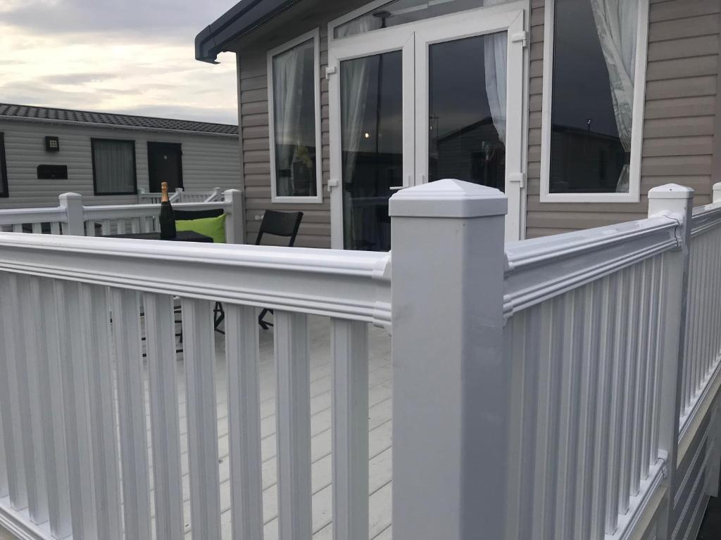 a white fence on a porch of a house at Flamingo Land Private Caravan - No 8 Cedarwood in Kirby Misperton