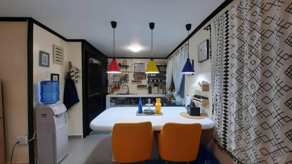 a kitchen with a table and two orange chairs at Pretty flat with full AC 