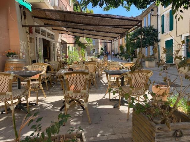 an outdoor patio with tables and chairs and an umbrella at la dame jeanne in Cucuron