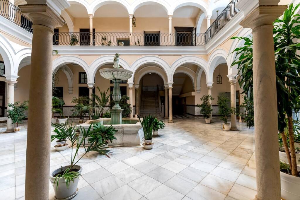 duży hol z fontanną i roślinami w obiekcie Apartamentos RG, San Vicente 22 w Sewilli