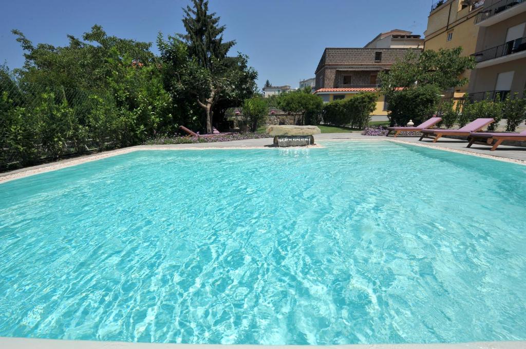 a large pool with blue water in a building at Residenza Villa Titina in SantʼAgata sui Due Golfi