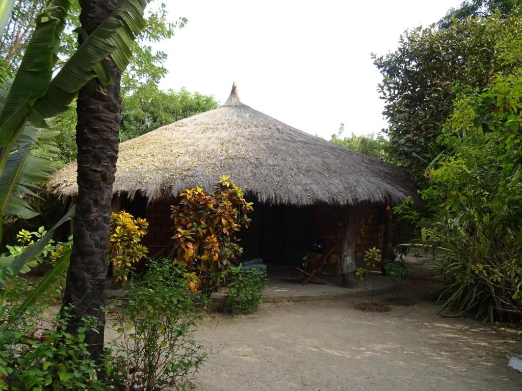 eine Hütte mit einem Strohdach in einem Wald in der Unterkunft Kansala Ta Toto in Kafountine