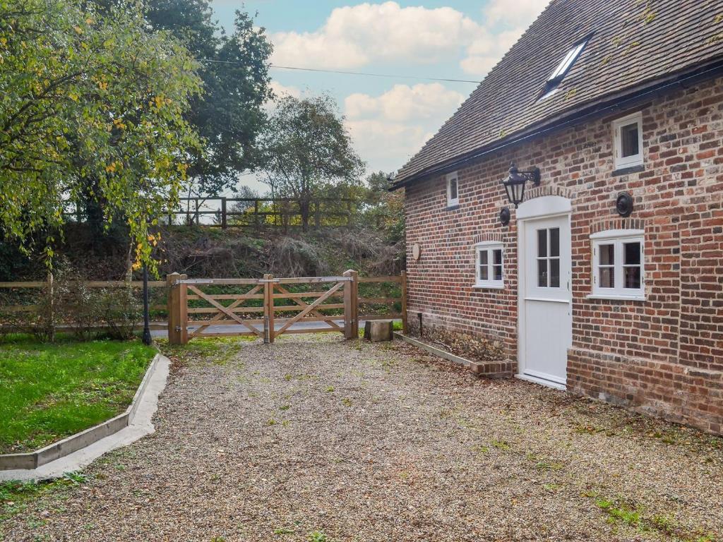 a brick building with a gate and a fence at The Granary in Little Chart