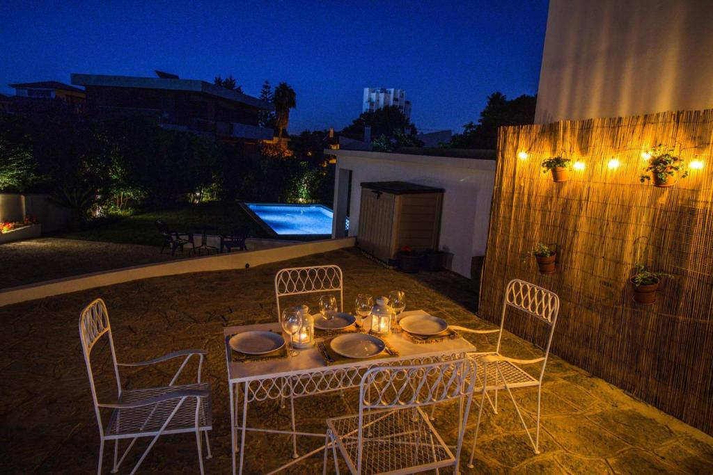 a table and chairs in a backyard at night at 188 Apartments - Lantana - pool, garden and patio in Cascais