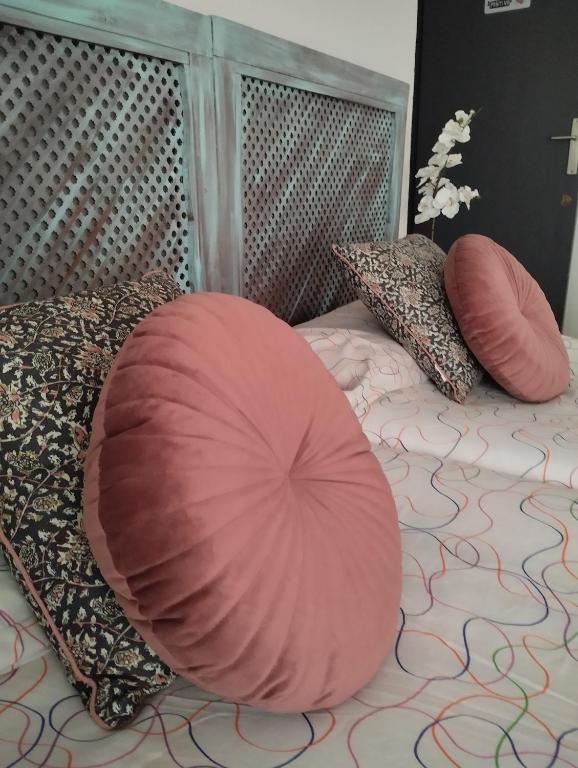 a bed with a large pink pillow on it at Céntrico piso con aparcamiento gratuito in Granada