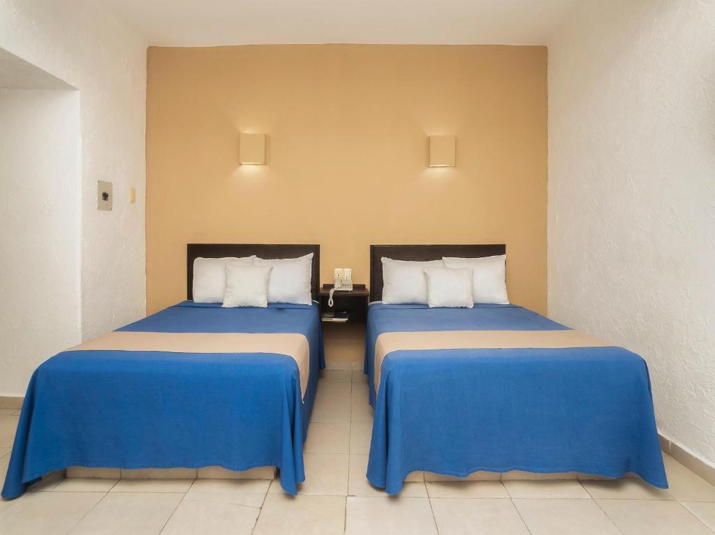 two beds sitting next to each other in a room at Hotel Trianon in Veracruz
