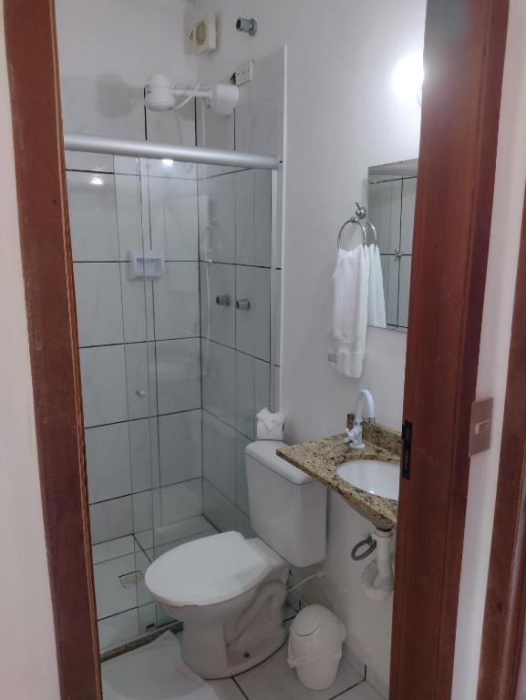 uma casa de banho com um WC, um chuveiro e um lavatório. em Hotel Portal da Praia em Barequeçaba