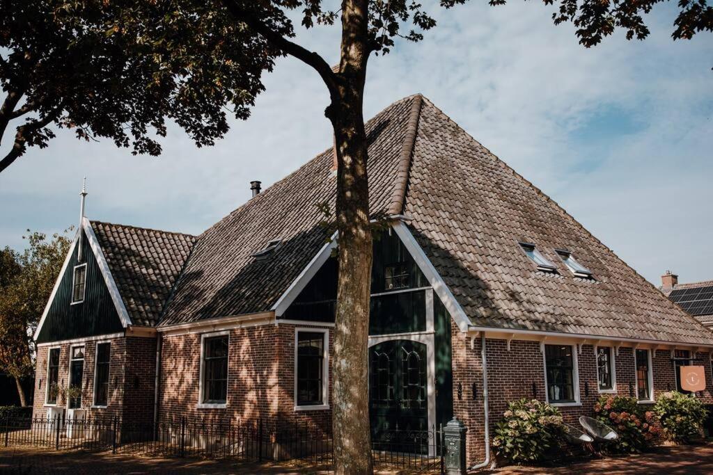 een stenen huis met een gambrel dak bij Monumentale stolpboerderij voorzien van alle gemakken van nu! in Twisk
