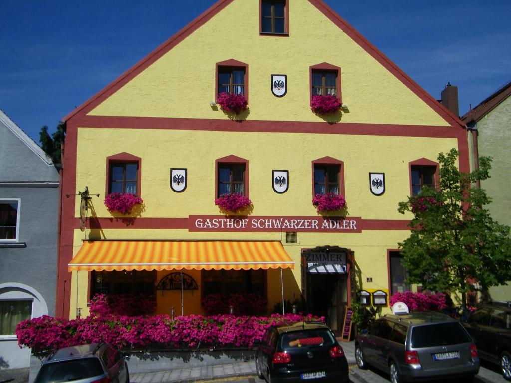 un bâtiment avec des fleurs devant un magasin dans l'établissement Gasthof Schwarzer Adler, à Nabburg