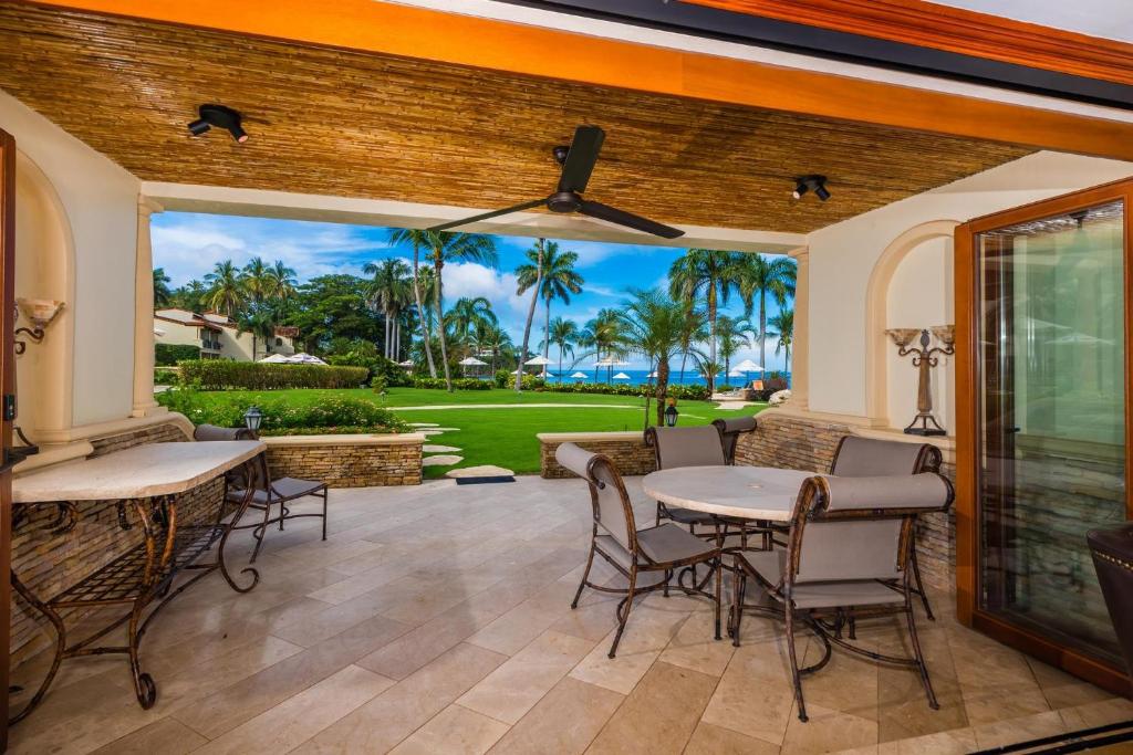 un patio avec tables et chaises et vue sur l'océan dans l'établissement Palms 23 Luxury Beachfront Villa, à Playa Flamingo