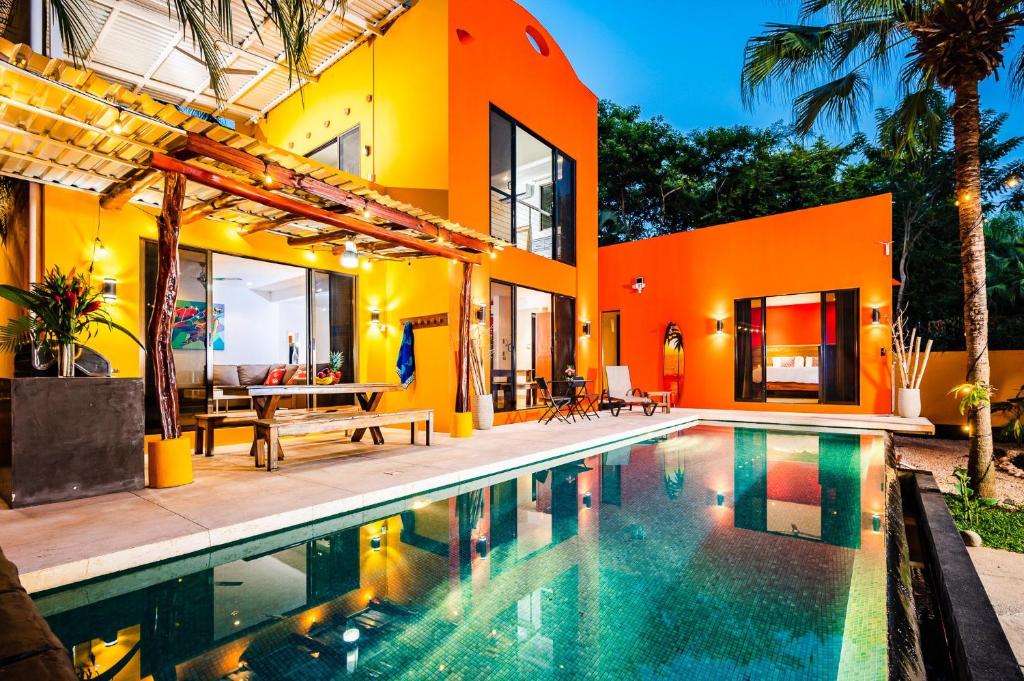 una casa naranja con piscina frente a ella en A Tamarindo Sunset, en Tamarindo