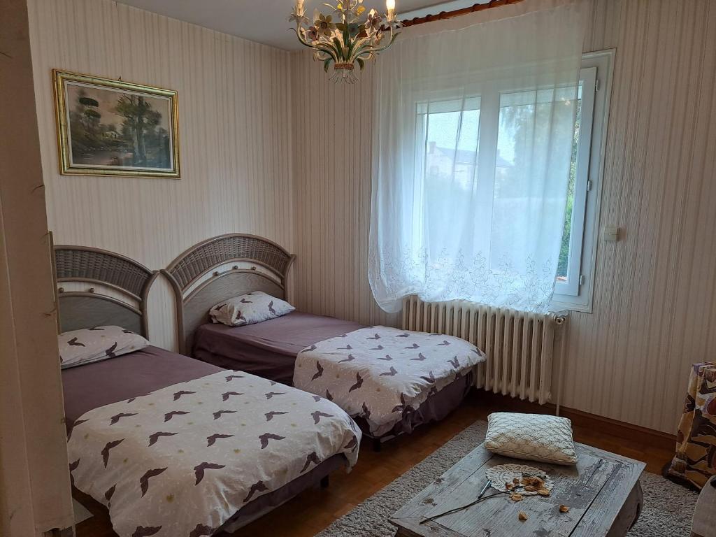 a bedroom with two beds and a window at Grain de blé Location in Toury